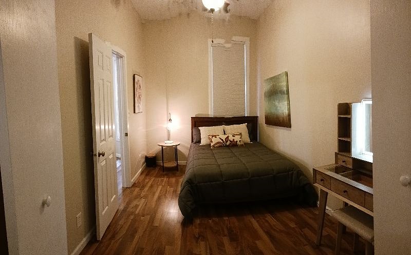 Back bedroom with night stand and vanity