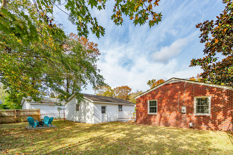 The fully fenced backyard features a cozy fire pit, perfect for unwinding in the evenings. 
