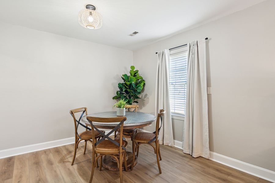 Adjacent to the kitchen is a dining area with a 4-person table and a dedicated workspace for remote work.