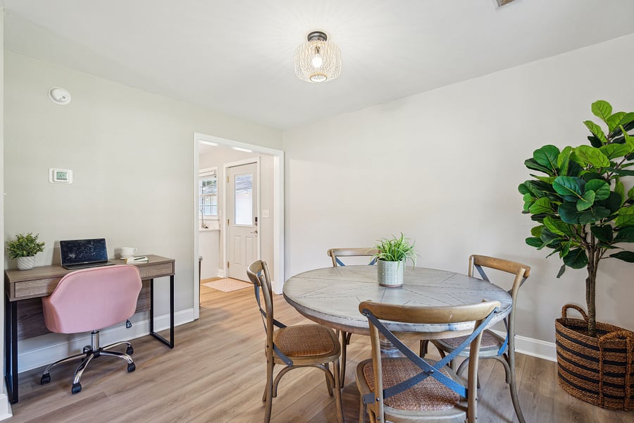Adjacent to the kitchen is a dining area with a 4-person table and a dedicated workspace for remote work.