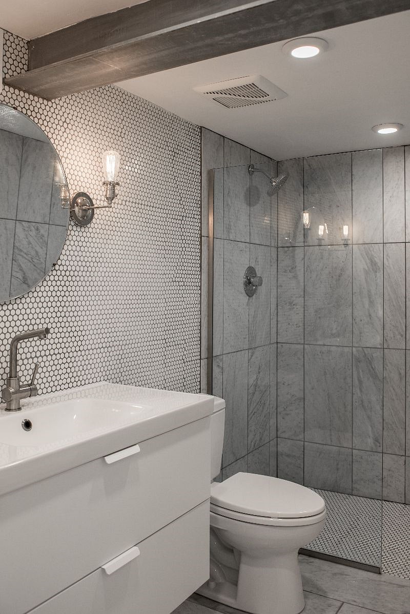 Luxe Bathroom finished in marble, penny-round tile, Toto toilet, frameless glass shower.
