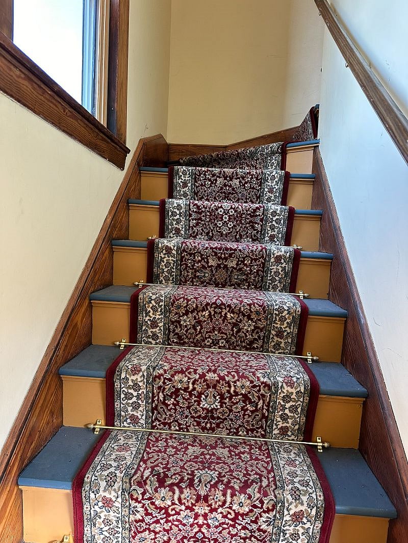 Rear interior stairs. The stairs are carpeted with padding to minimize noise to tenants.

