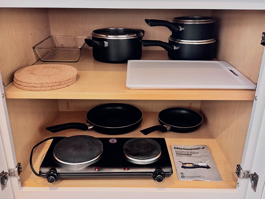 Light mealfriendly setup!
This cabinet includes a hot plate, pots, pans, cutting board, and more  great for quick bites and simple meals at home 