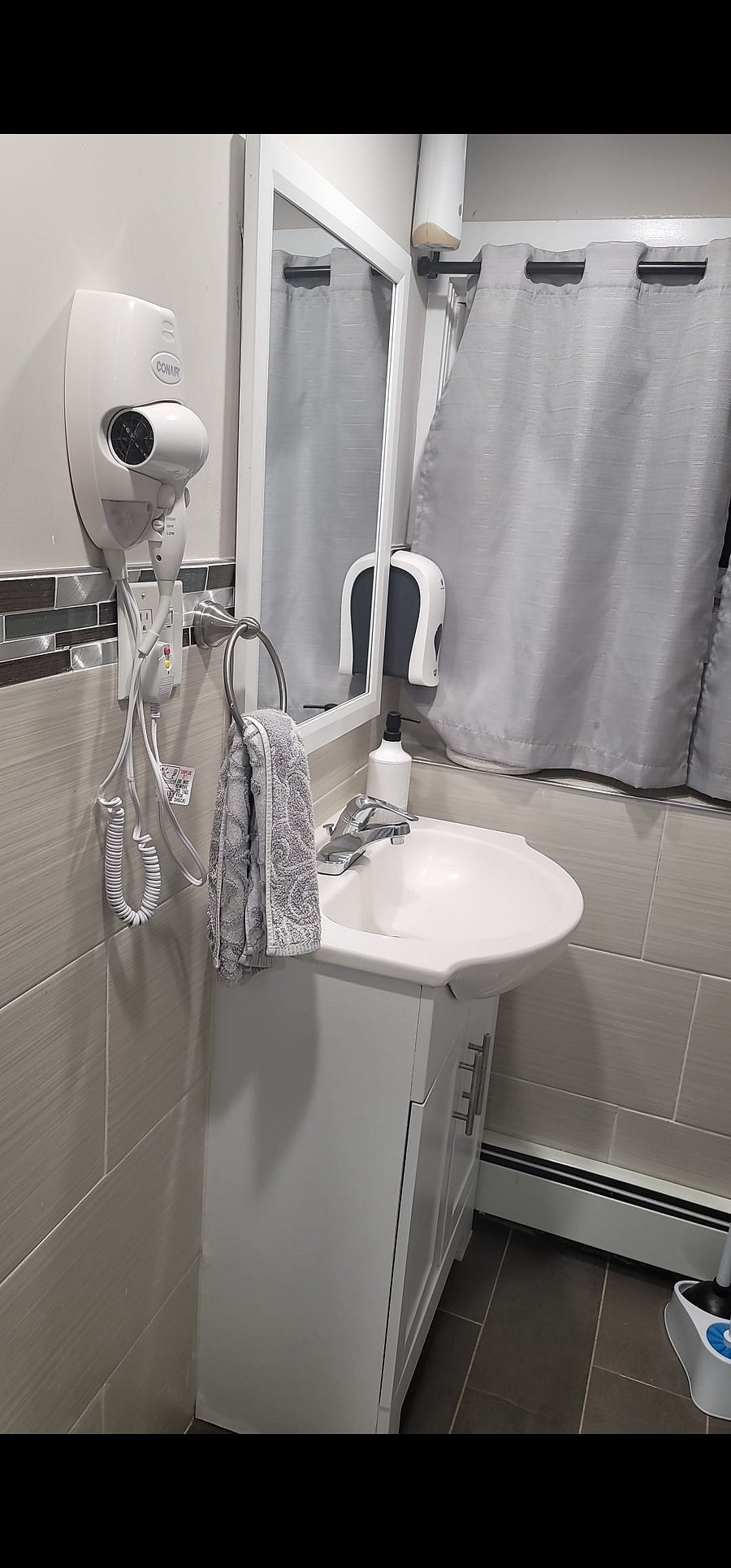 Hair dryer and clean bathroom accessible.