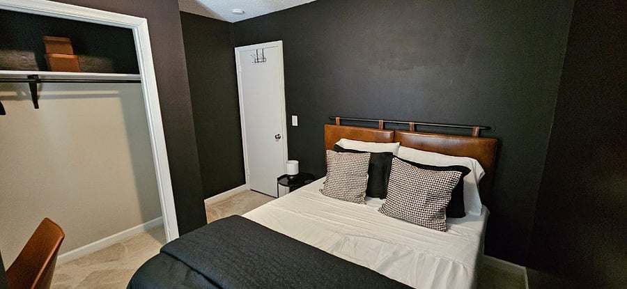 First bedroom with Queen-sized mattress, spacious closet, a desk, a dresser, room-darkening/blackout curtains, and a Roku flatscreen TV.