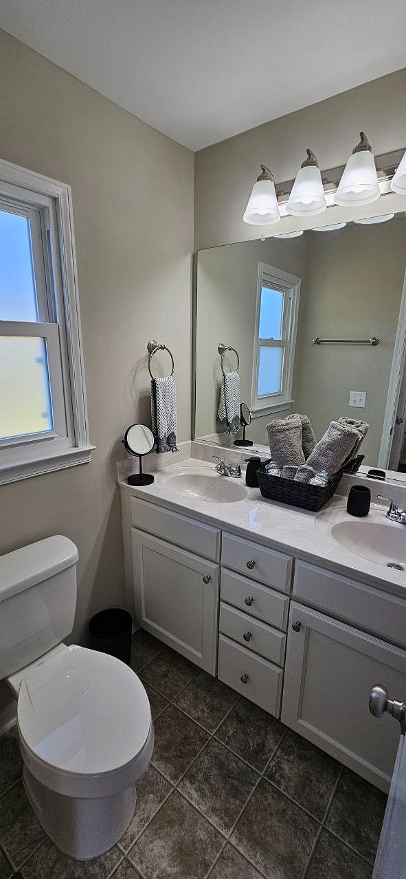 Bathroom in primary suite with stand-up shower and double sinks.