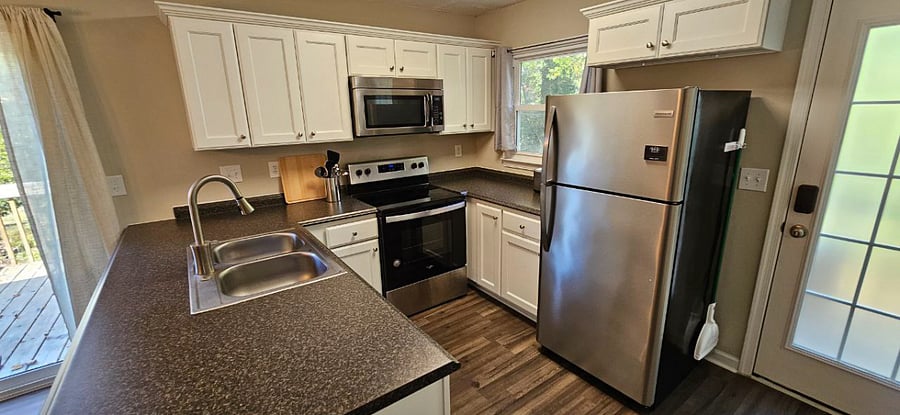 Kitchen with stainless steel fridge, stove/oven, microwave, and dishwasher. With a coffee bar and ample cabinet storage just steps away.