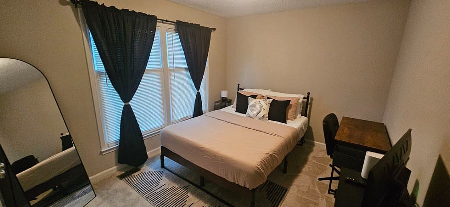 Second bedroom with Queen-sized mattress, spacious closet, a desk, a dresser, room-darkening/blackout curtains, and a Roku flatscreen TV.