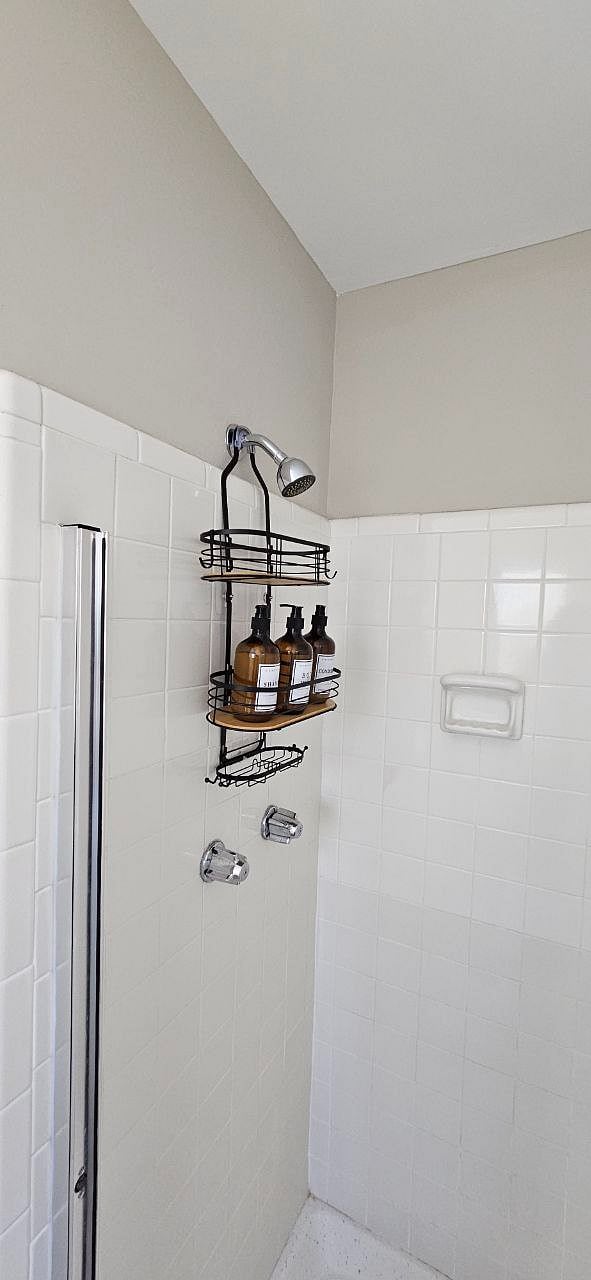 Bathroom in primary suite with stand-up shower and double sinks.