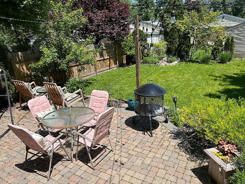 The backyard has patio furniture and a hammock, vegetable garden and flowers. 