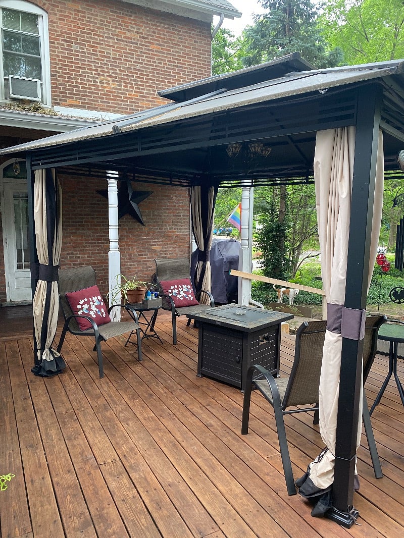 Outdoor covered patio with fire pit grill and hot tub.