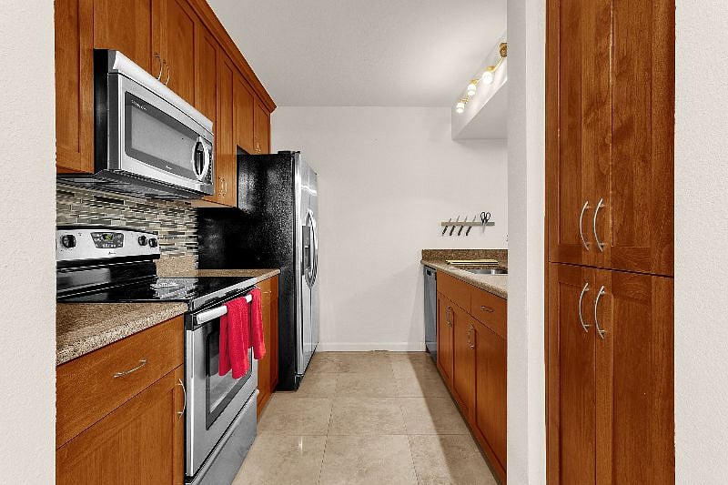 Kitchen with large refrigerator, microwave oven, blender, toaster and crockpot.  It is fully stocked with dishes, glasses, pots and pans.