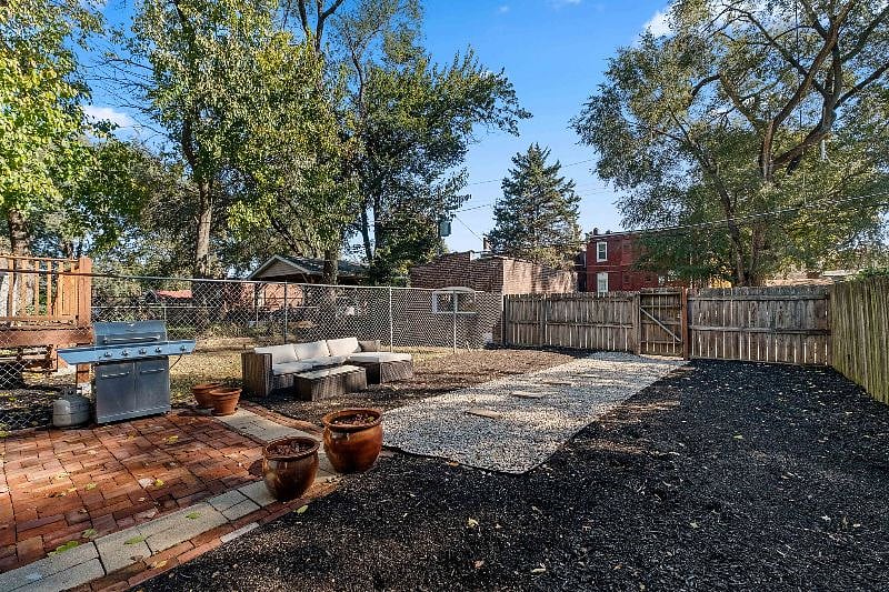 Backyard with outdoor couch, propane grill and patio