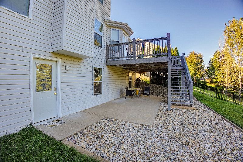 View of entrance door with sit-out chair and table under the deck.