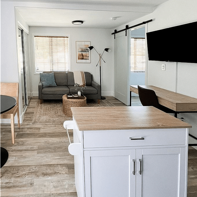 Living area w/ sofa, desk and smart Roku TV.