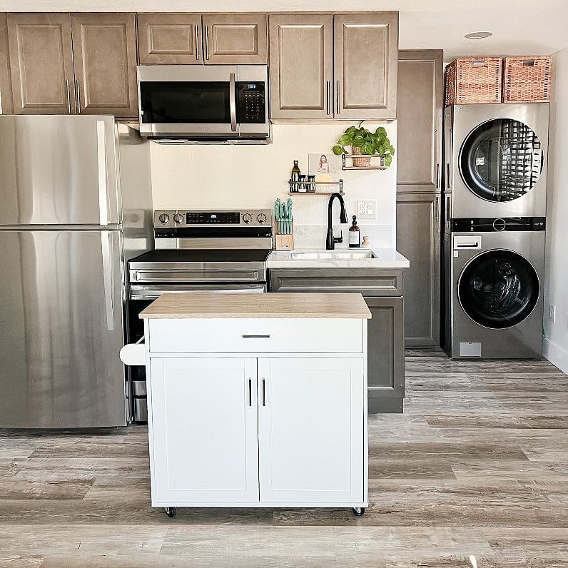 Kitchenette w/ view of full laundry and storage cabinets.