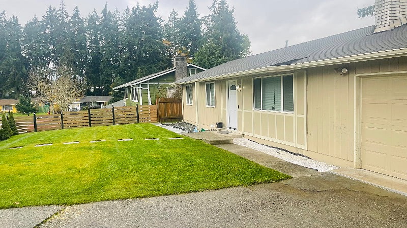 large, fenced beautifully manicured front yard