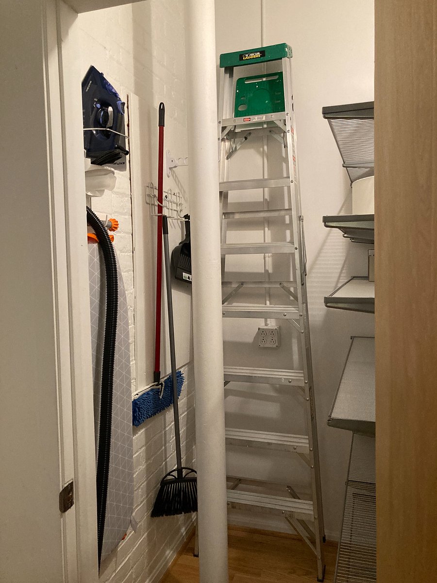 Walk-in closet with shelving, ironing supplies, vacuum, broom, dust mop.  Great place for storing empty luggage.
