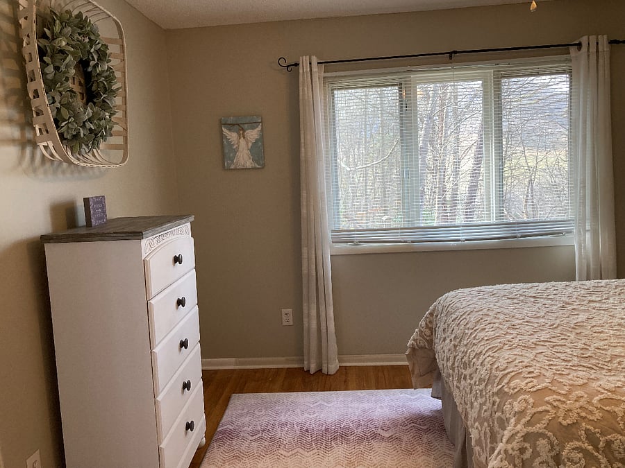 Downstairs bedroom with queen bed, dresser and closet.