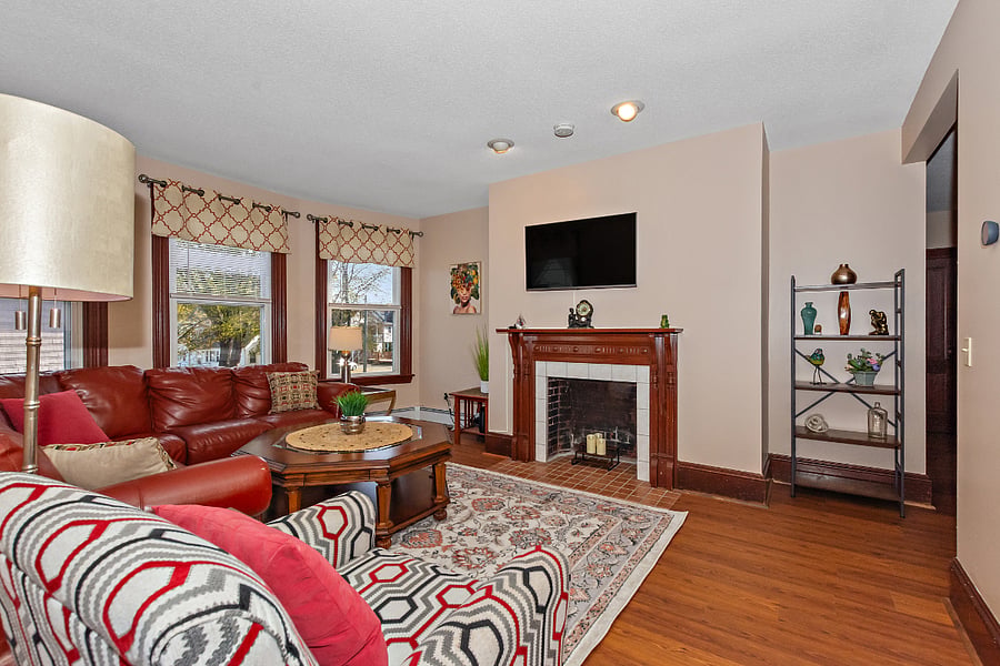 Living room features a (non-working) fireplace, Smart TV, leather sectional and comfy chair.