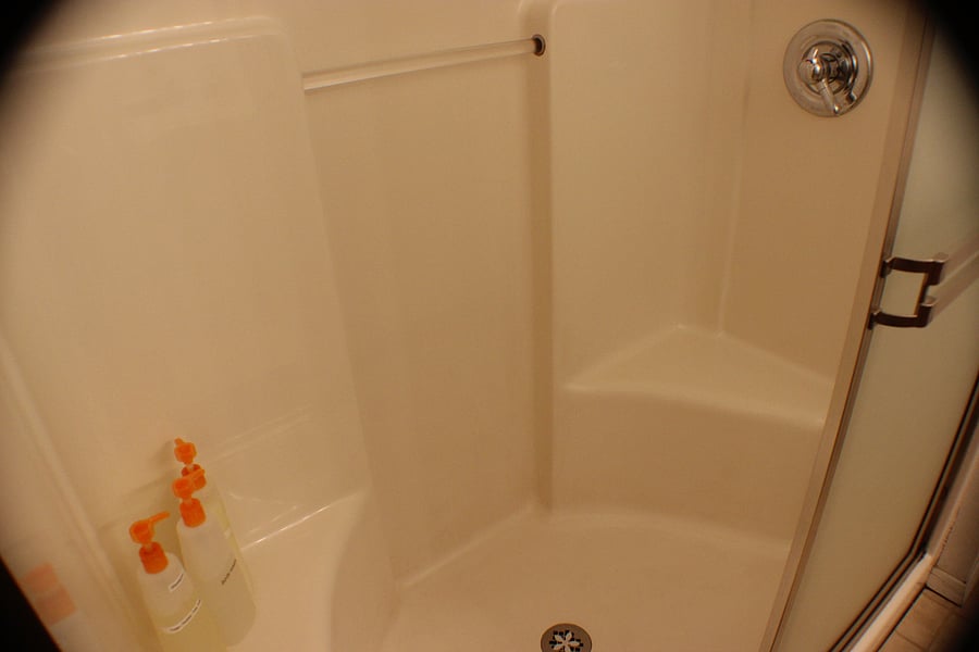 Shower stall has two small benches