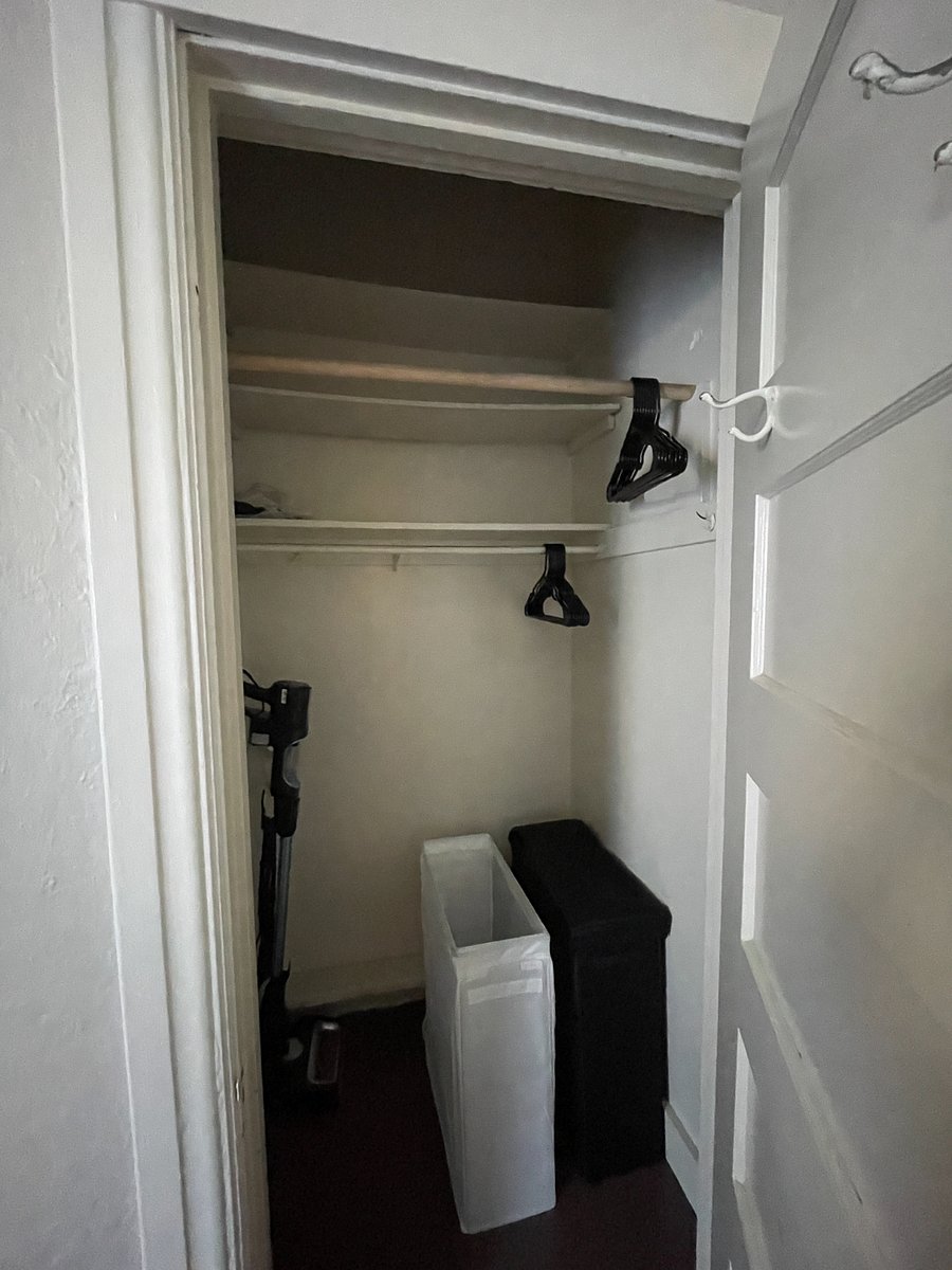 Bedroom closet with double closet rod and complimentary laundry baskets.