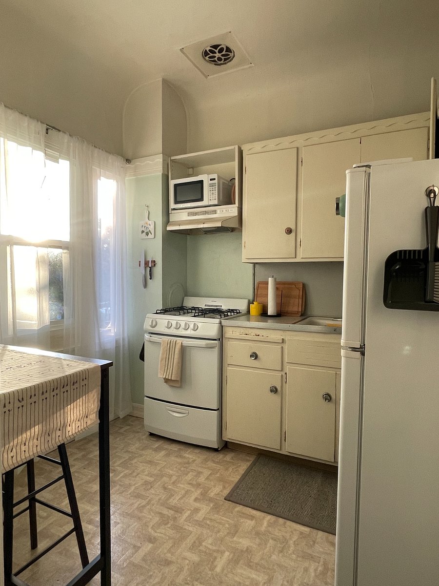 Kitchen features a gas range, microwave, coffee maker and electric kettle.
