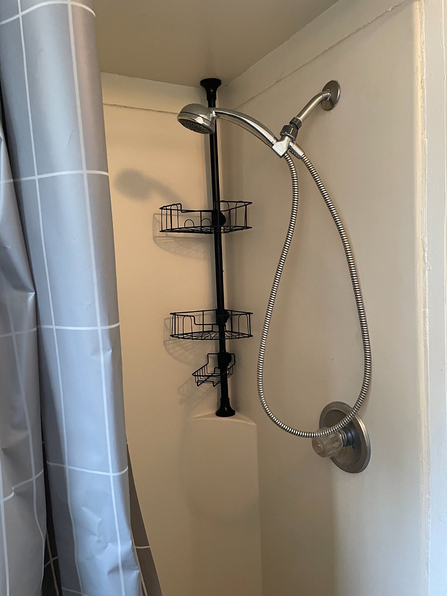 Shower includes detachable showerhead and extra shelf space.