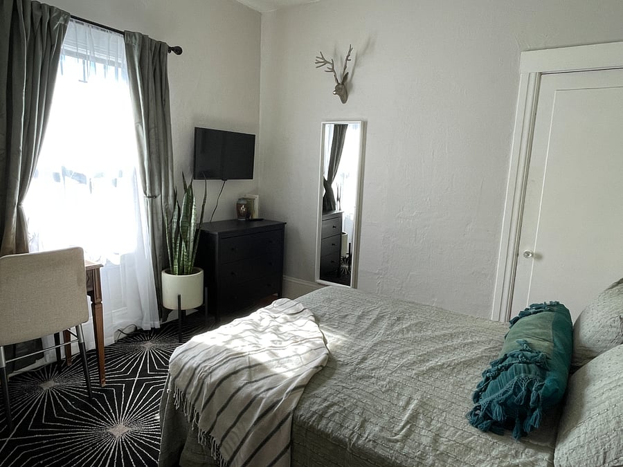 Bedroom with full bed, desk, dresser and smart TV. Room is south facing with beautiful daytime light, and also includes blackout curtains.