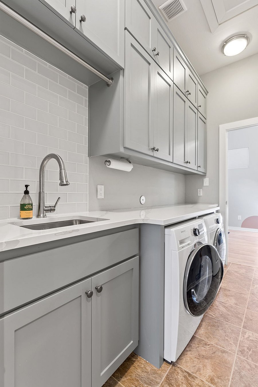 Laundry room with quartz countertops and sink, tons of storage, and Samsung washer/dryer