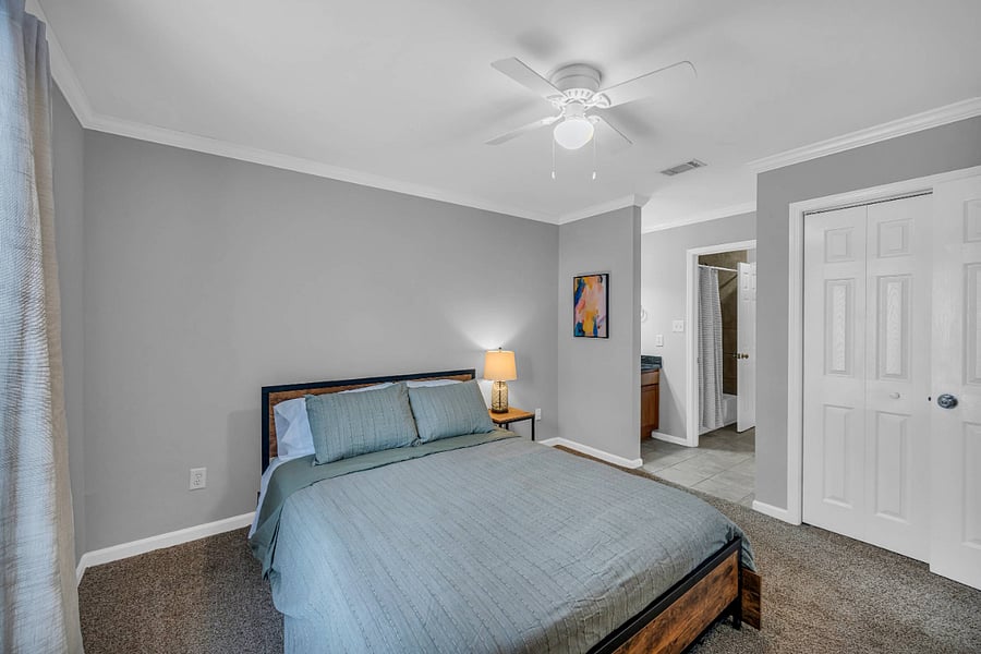 Front bedroom with queen bed and storage drawers. Private vanity area with sink.
