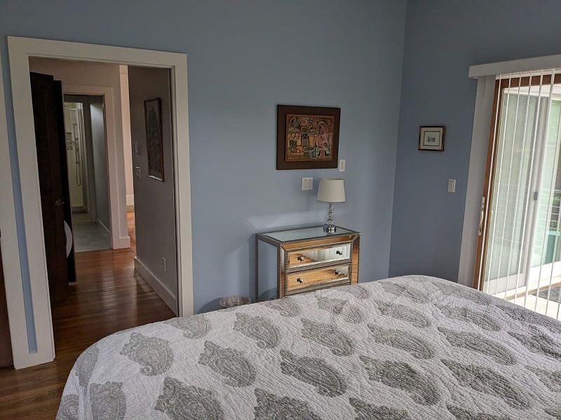The bedroom has a closet, small dresser, and access to the back porch via sliding glass doors.