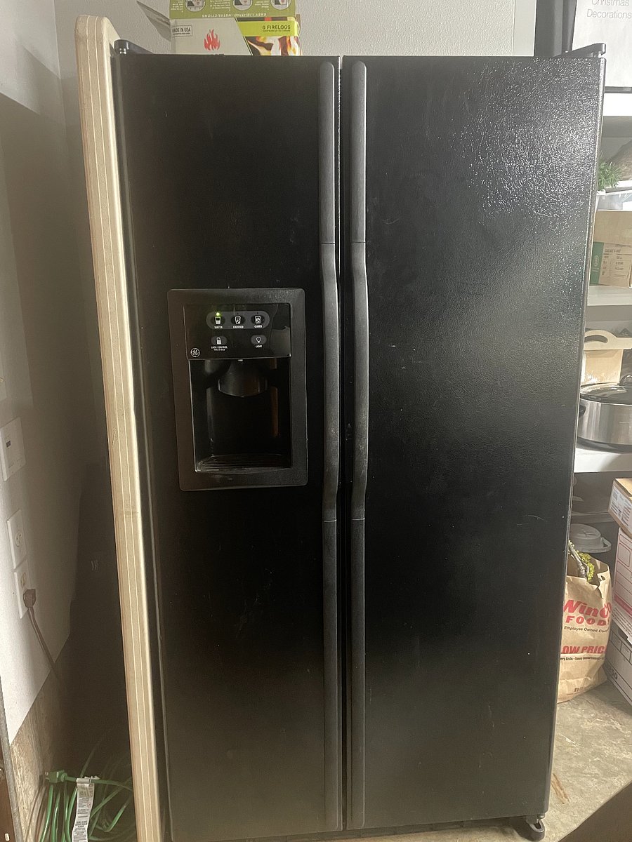 Full size refrigerator in insulated garage just steps away from inside entrance.