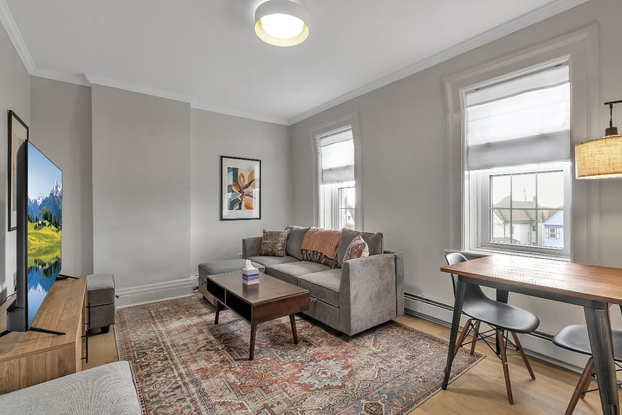 Spacious living room with lake views, a 65" Roku TV and couch that can be reconfigured into a double bed