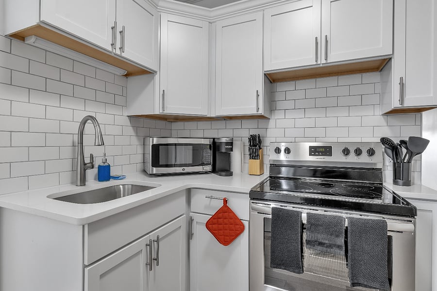 Completely rebuilt kitchen with quartz countertops, soft close cabinets, crown molding, subway tile backsplash and stainless steel appliances