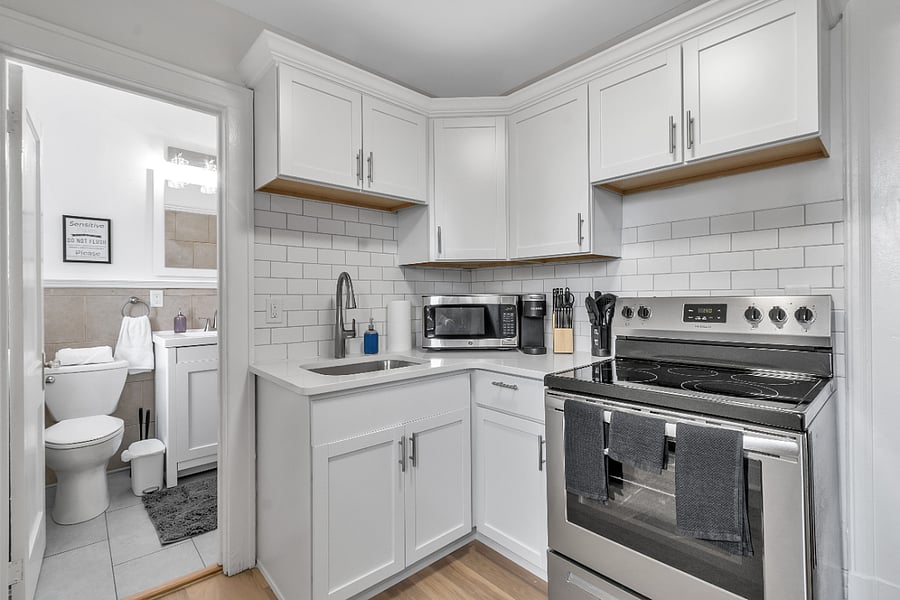 Completely rebuilt kitchen with quartz countertops, soft close cabinets, crown molding, subway tile backsplash and stainless steel appliances