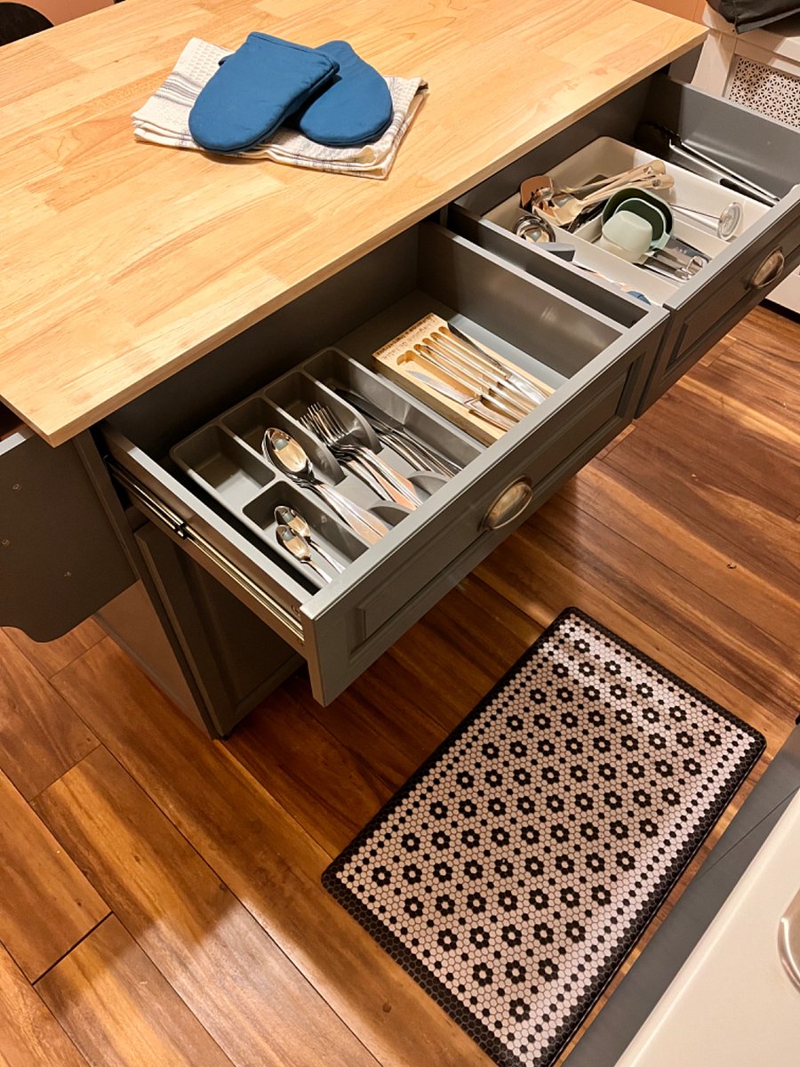 Kitchen is fully-stocked with eating and cooking utensils.