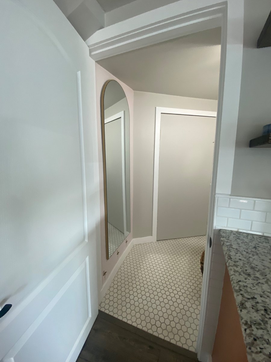 bathroom entry with full length mirror and custom floors.