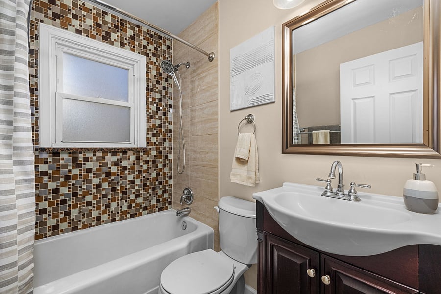 Get-started bathroom supplies include shower and toilet cleaners, toilet brush and plunger (hey, you never know). Tub surround includes two nice alcoves (out of view behind curtain) for shampoo/conditioner loofas and soaps. 