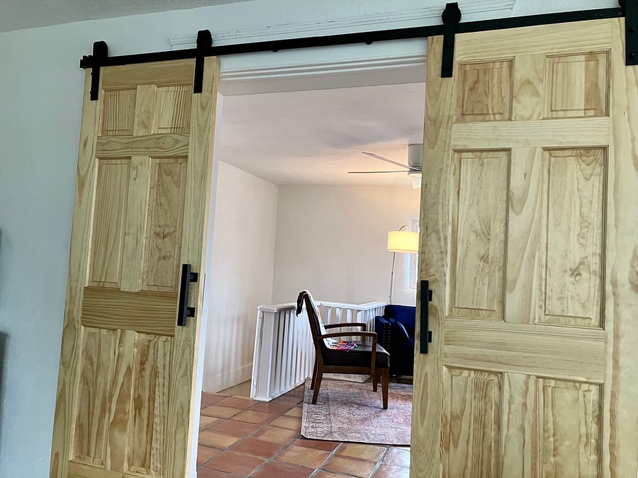 Barn doors separate the front bedroom (queen) from the living area.