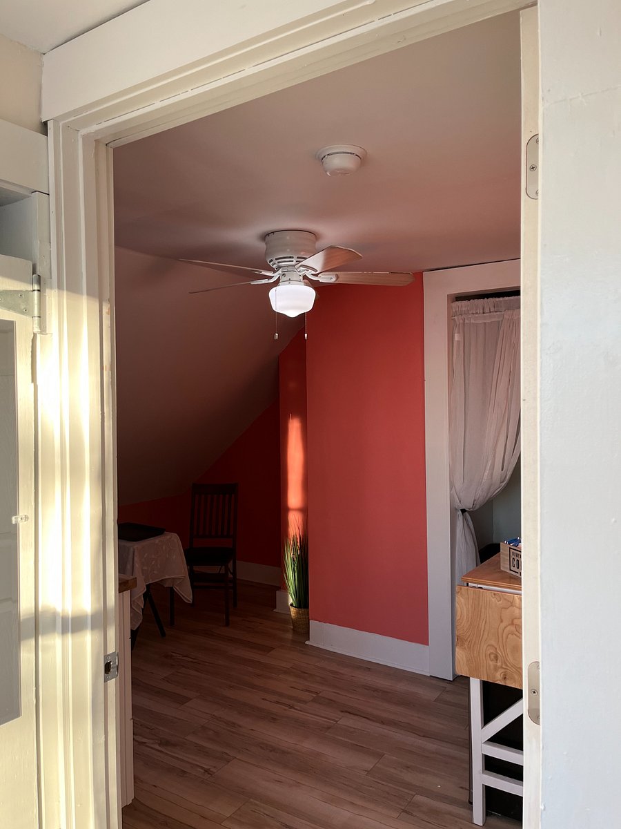 Kitchenette has a full sink, a small fridge, microwave, dishes, and glassware.