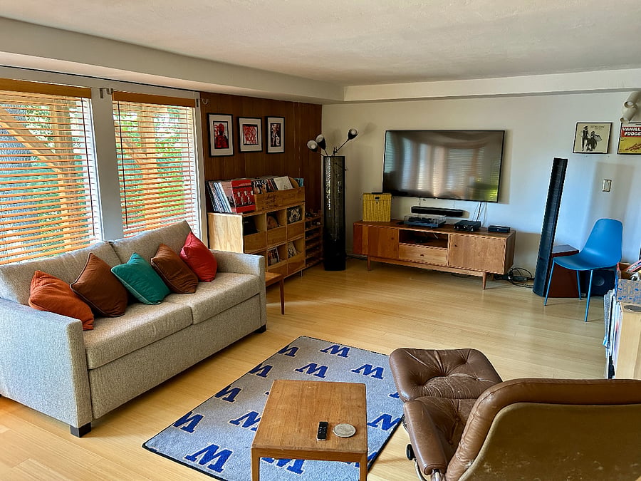 A second living room with workout space and room & board coach with bed.