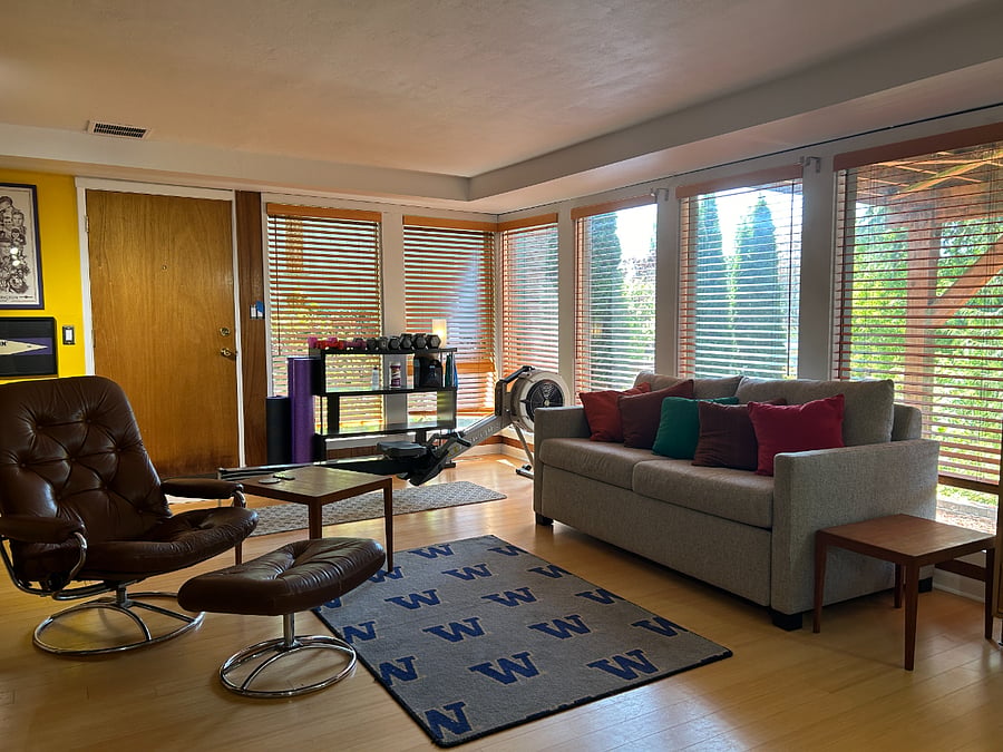 A second living room with workout space and room & board coach with bed. 