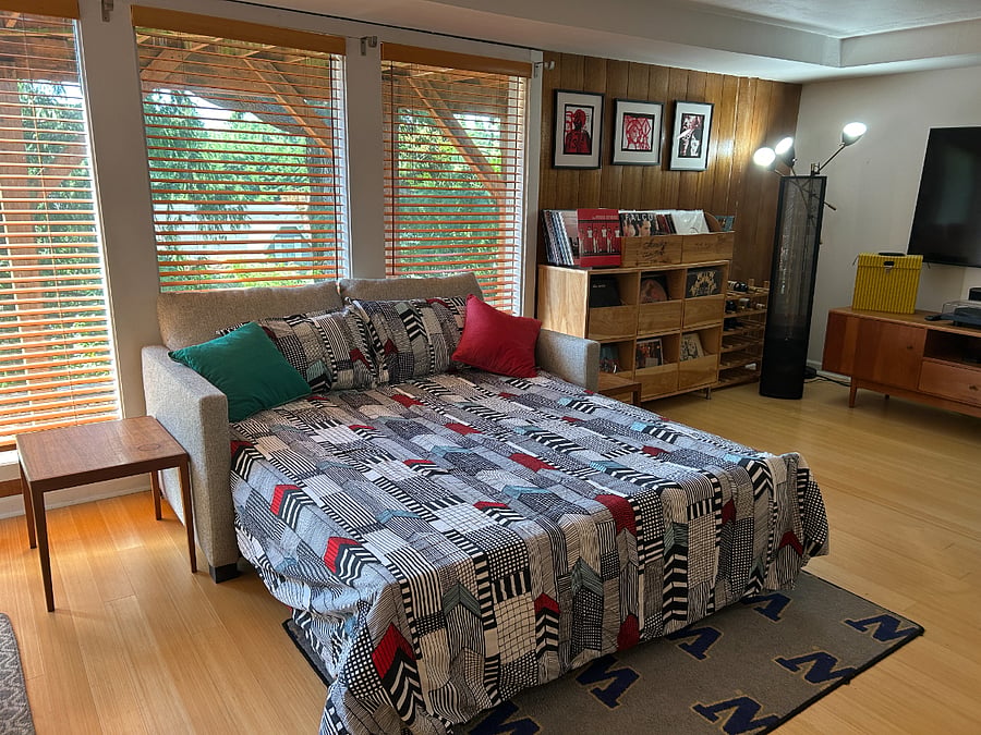 A second living room with workout space and room & board coach with bed. 