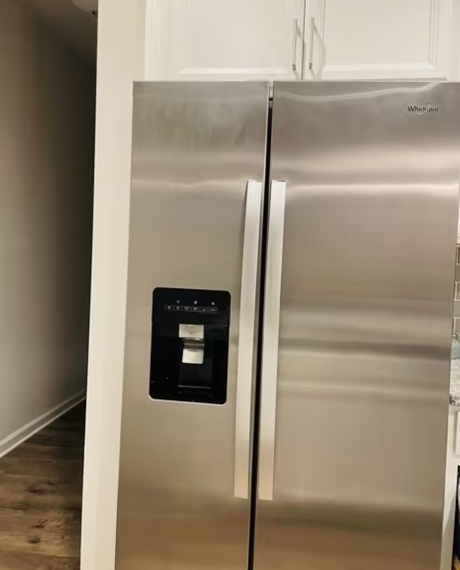 Stainless steel side by side refrigerator and freezer includes an ice maker and filtered water

