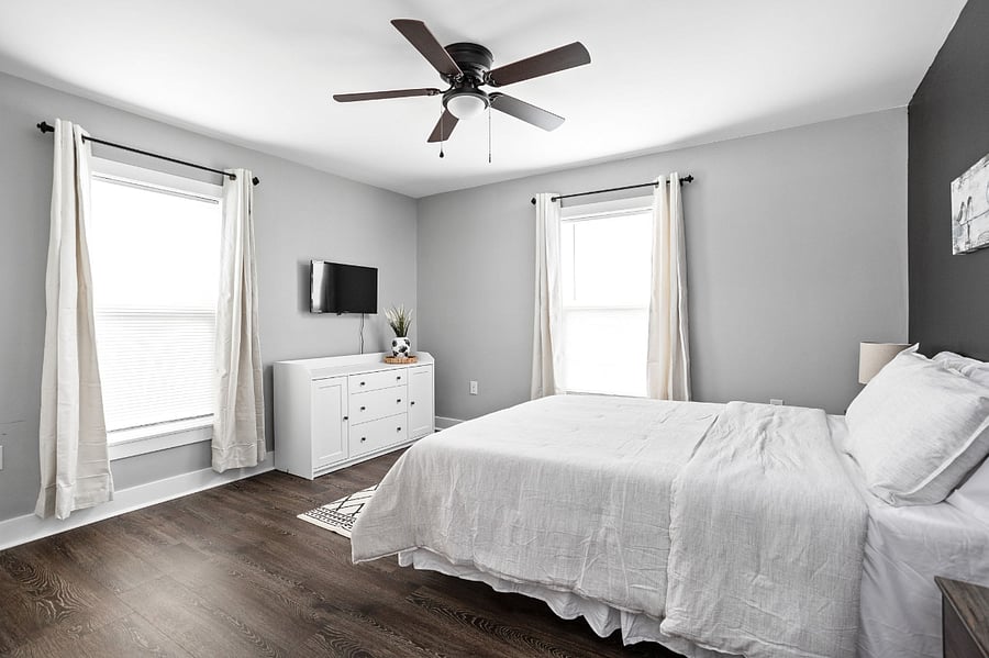 Cozy up in bedroom featuring a queen bed, closet, TV and a stylish accent wall.