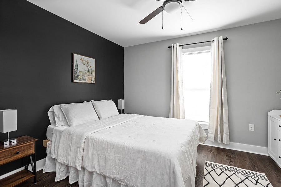 Another view of the 2nd bedroom with tv, queen bed, dresser, and closet.