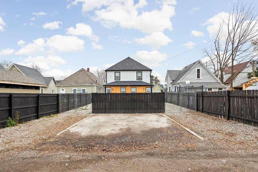 Backyard with fenced-in parking, offering enough space to comfortably fit 1-2 cars for your convenience.