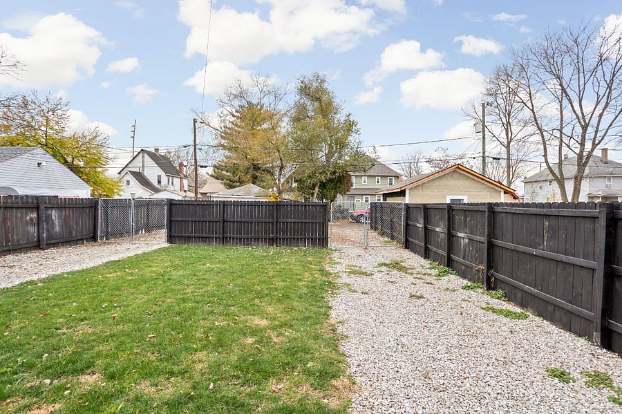 Backyard with fenced-in parking, offering enough space to comfortably fit 1-2 cars for your convenience.