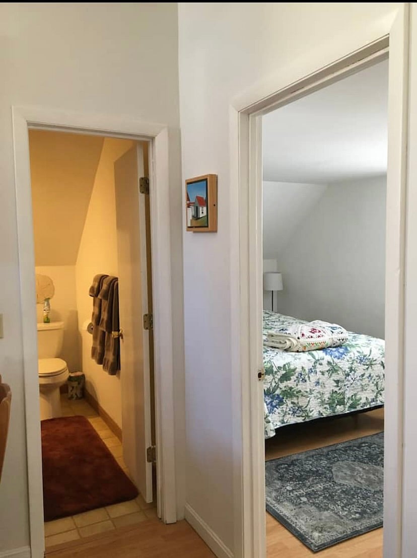 Bathroom with shower, bedroom.